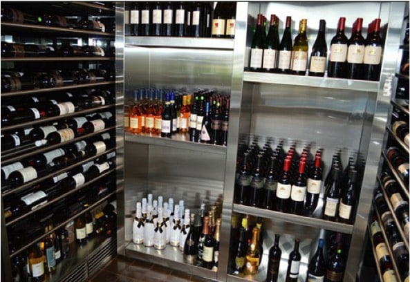 A wine cellar with a cooling unit by US Cellar Systems